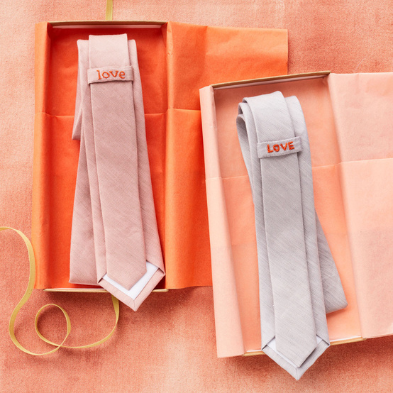 two neckties in orange boxes with love embroidered on them