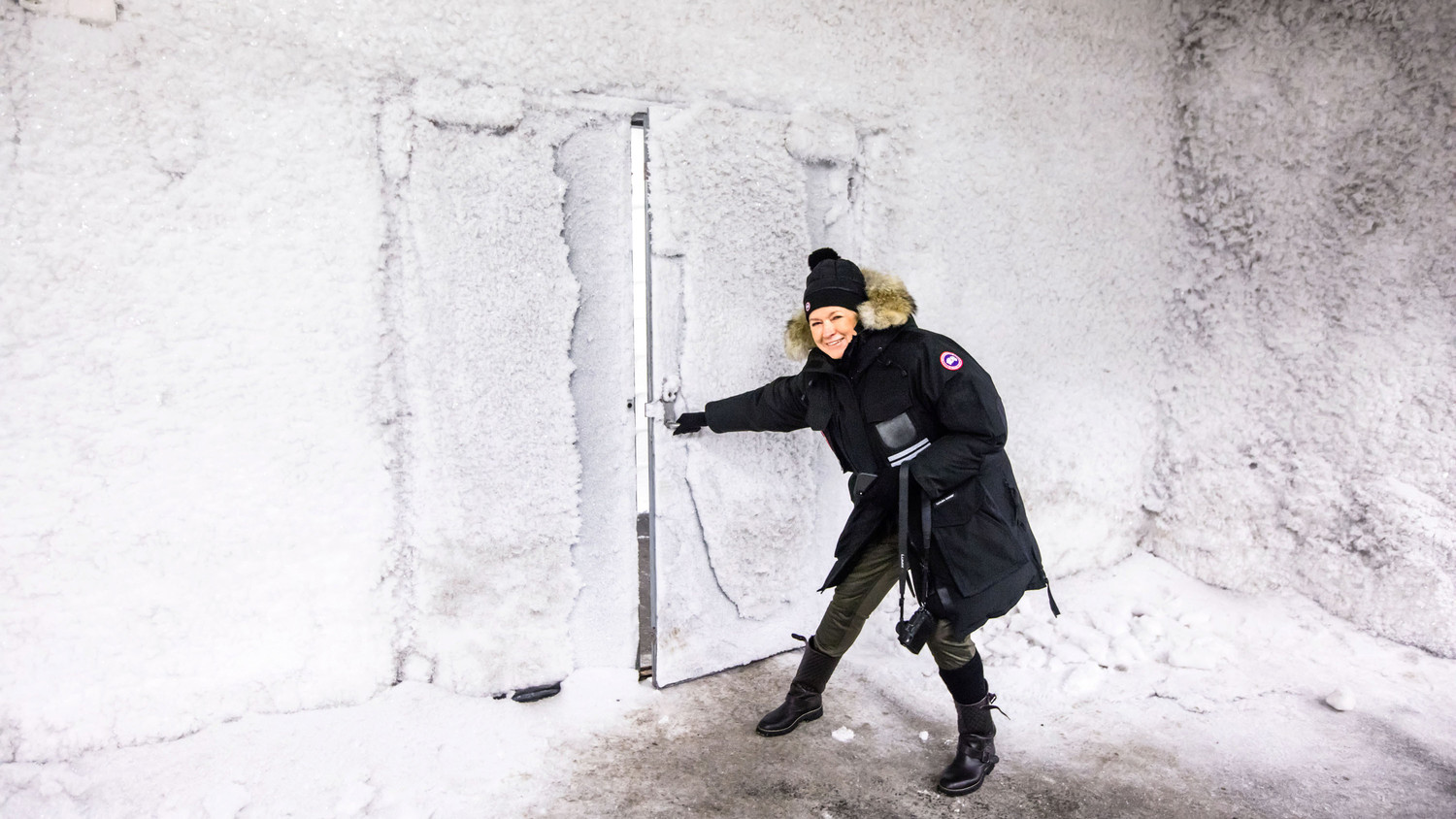 martha wearing winter gear opening door to svalbard global seed vault