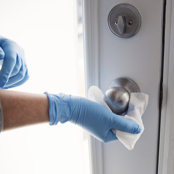 hand cleaning a doorknob