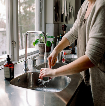 woman washing dishes with brush