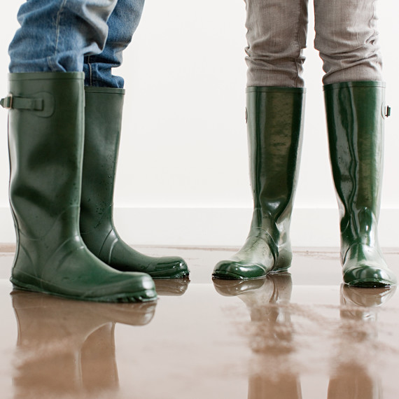 People in boots cleaning up after a flood. People in boots cleaning up after a flood.