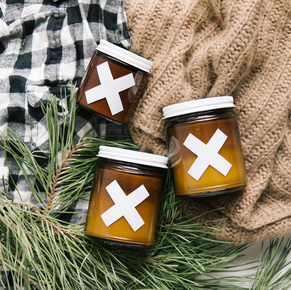 autumn candles against sweaters and pine branches autumn candles against sweaters and pine branches
