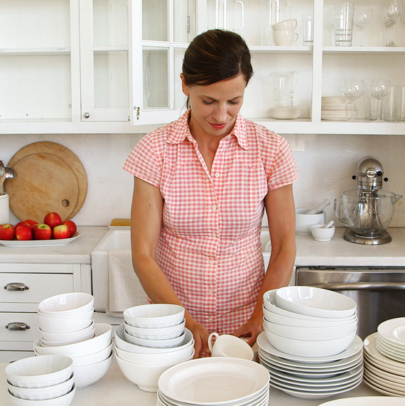 woman organizing white dishes in kitchen woman organizing white dishes in kitchen