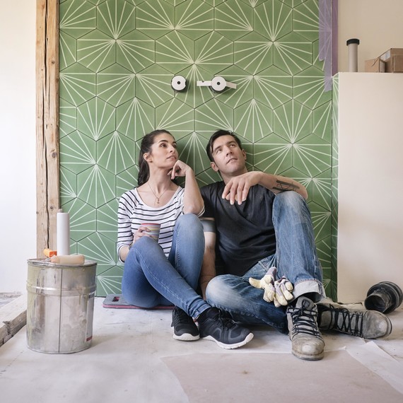 couple sitting on the floor of a bathroom being renovated couple sitting on the floor of a bathroom being renovated