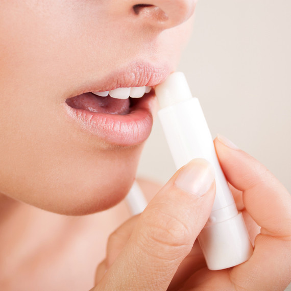 woman putting on lip balm woman putting on lip balm