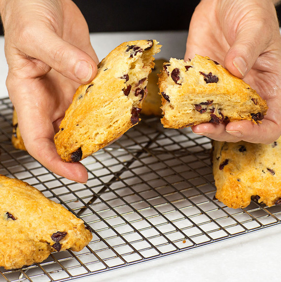 hands holding flaky cranberry scones hands holding flaky cranberry scones