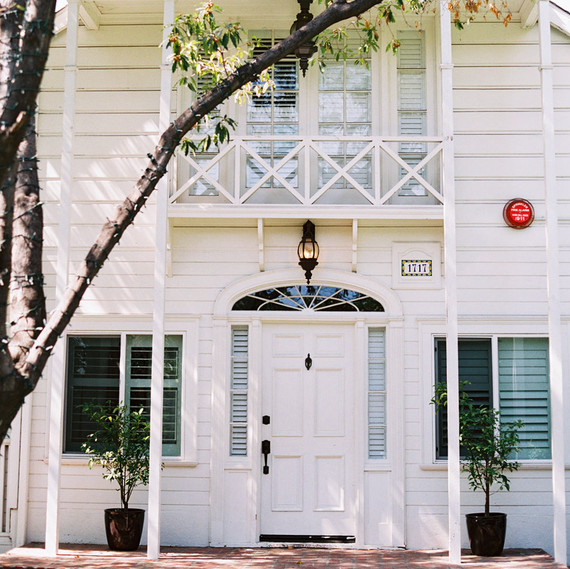 front exterior white house with balcony and trees