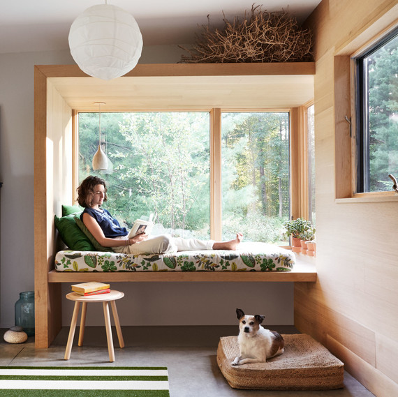 woman sitting in window seat in mudroom woman sitting in window seat in mudroom