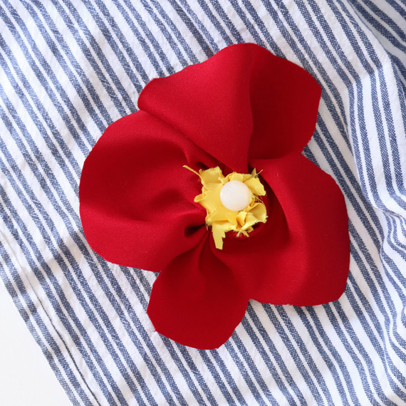 red silk remembrance poppy on blue striped towel red silk remembrance poppy on blue striped towel