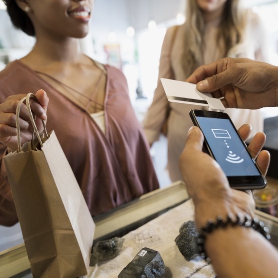 A woman is paying for an item with her credit card in a store A woman is paying for an item with her credit card in a store