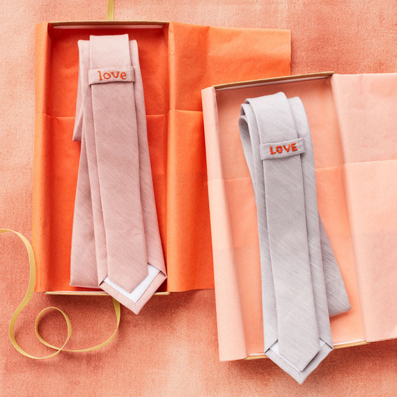 two neckties in orange boxes with love embroidered on them two neckties in orange boxes with love embroidered on them