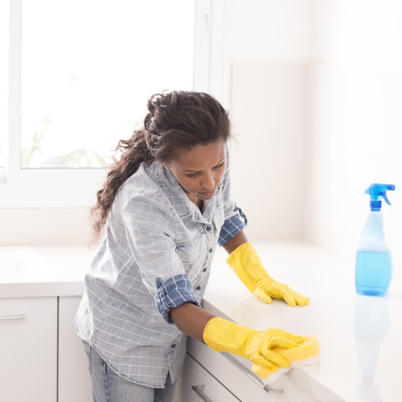 woman scrubbing a kitchen surface woman scrubbing a kitchen surface