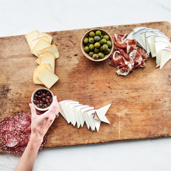 grazing board summer step 4 meats dips cheese wooden hand holding olives grazing board summer step 4 meats dips cheese wooden hand holding olives