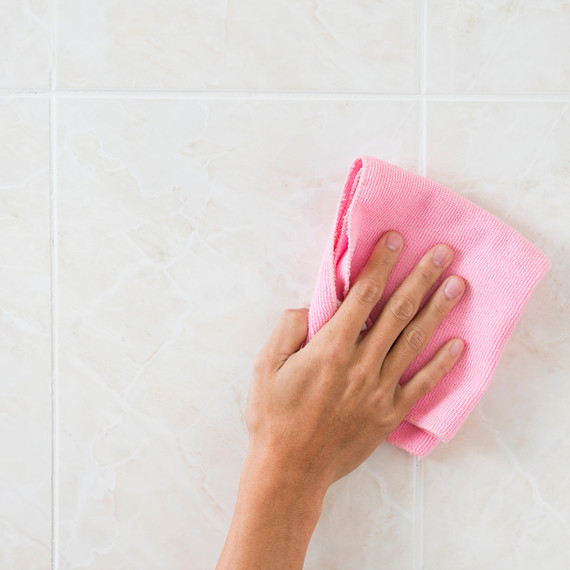 hand holding pink towel cleaning tile hand holding pink towel cleaning tile