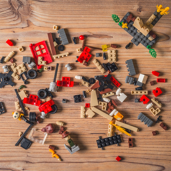 lego pieces scattered on wood floor lego pieces scattered on wood floor