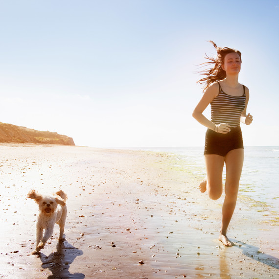 woman and dog running on beach woman and dog running on beach