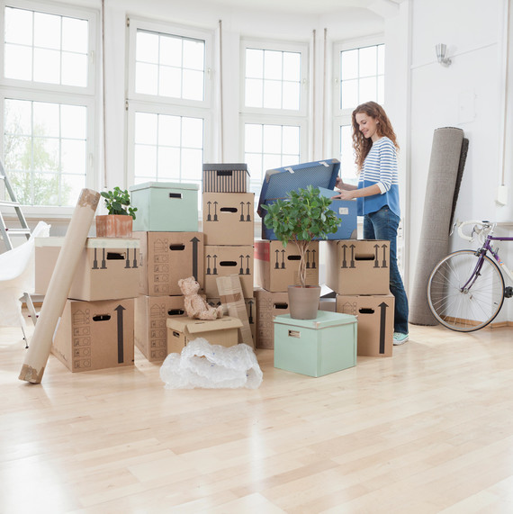 woman unpacking boxes in new apartment woman unpacking boxes in new apartment