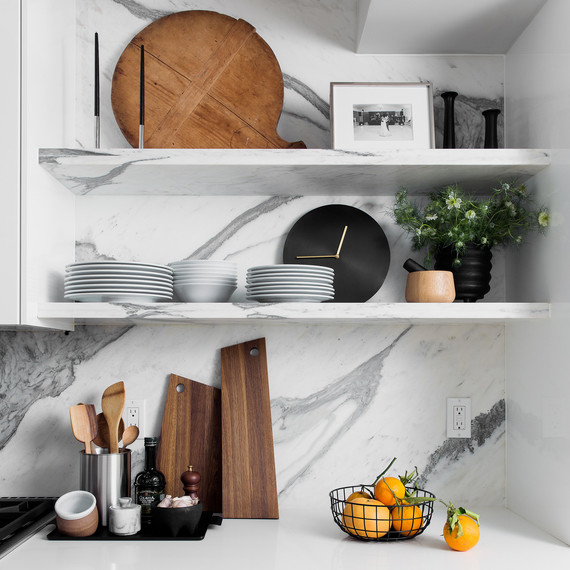 kitchen with marble backsplash and basket of oranges on countertop