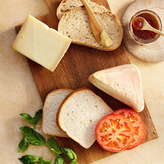 bread butter cheese and tomatoes on cutting board bread butter cheese and tomatoes on cutting board