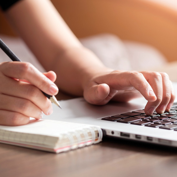 hands writing in notebook and typing on laptop hands writing in notebook and typing on laptop