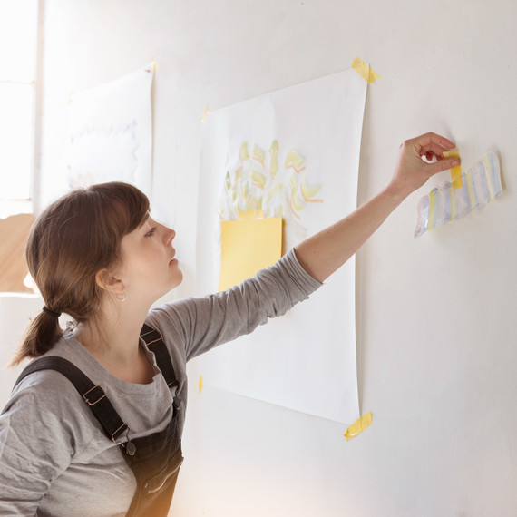 woman taping paper on wall woman taping paper on wall