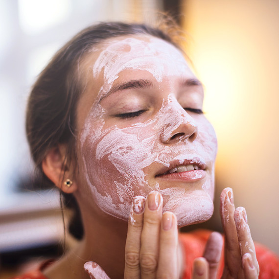woman applying facial mask woman applying facial mask
