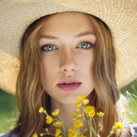 Caucasian Woman Wearing a Hat and Holding Wildflowers Caucasian Woman Wearing a Hat and Holding Wildflowers