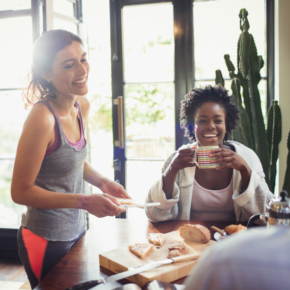 two women laughing at breakfast table two women laughing at breakfast table