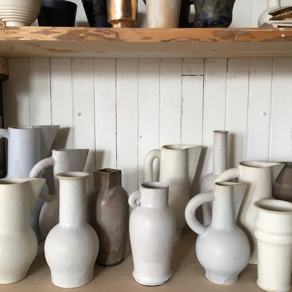 white ceramic vessels on shelf white ceramic vessels on shelf