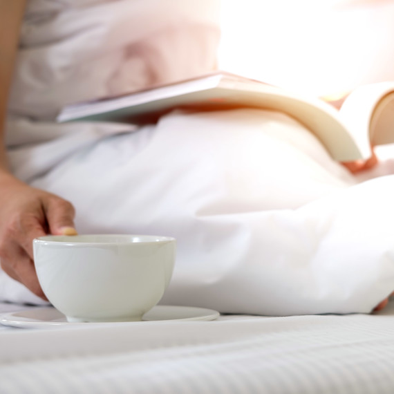 relaxing in bed with book and morning coffee relaxing in bed with book and morning coffee