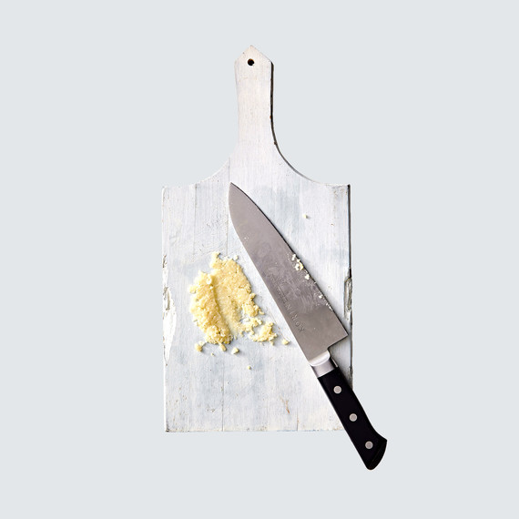 garlic mashed for dressing on cutting board with knife garlic mashed for dressing on cutting board with knife