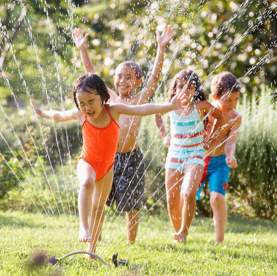 kids running through sprinkler suburbs lawn grass kids running through sprinkler suburbs lawn grass