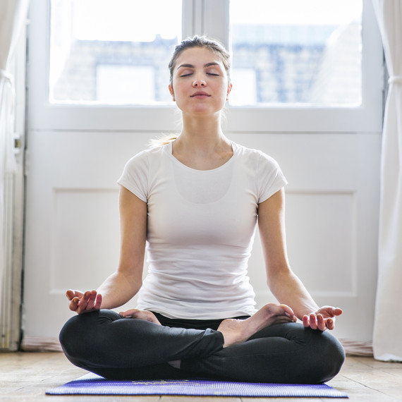 brunette woman meditating on yoga mat brunette woman meditating on yoga mat