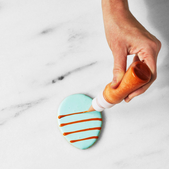 martha decorating cookie with orange icing martha decorating cookie with orange icing