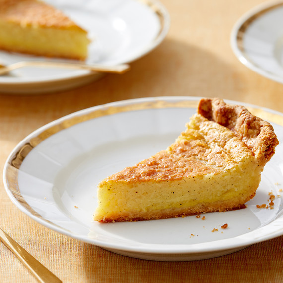 a slice of buttermilk cardmom pie on a gold and white plate a slice of buttermilk cardmom pie on a gold and white plate