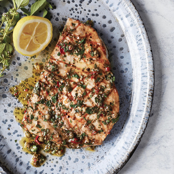 swordfish with sicilian oregano-caper sauce served on a blue speckled plate swordfish with sicilian oregano-caper sauce served on a blue speckled plate
