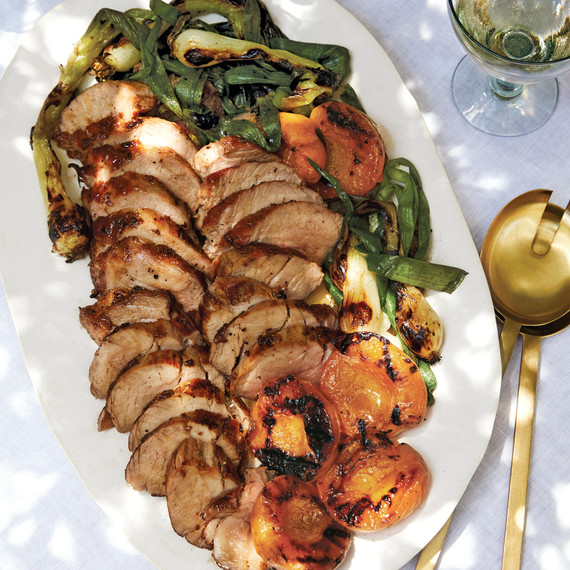 honey-glazed pork tenderloin with grilled apricots served on a white platter honey-glazed pork tenderloin with grilled apricots served on a white platter