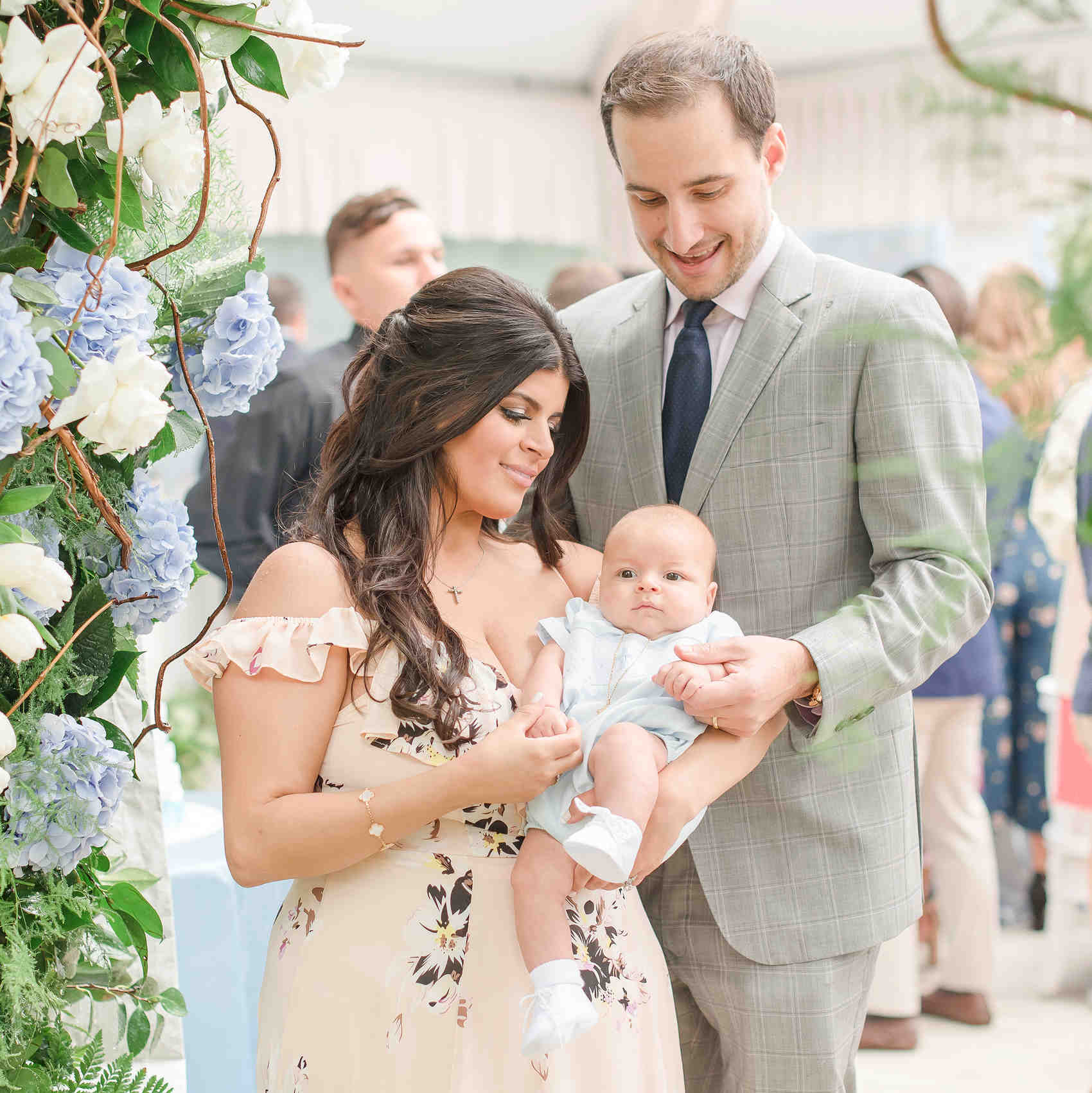 charitable baptism celebration couple with baby by floral arch charitable baptism celebration couple with baby by floral arch